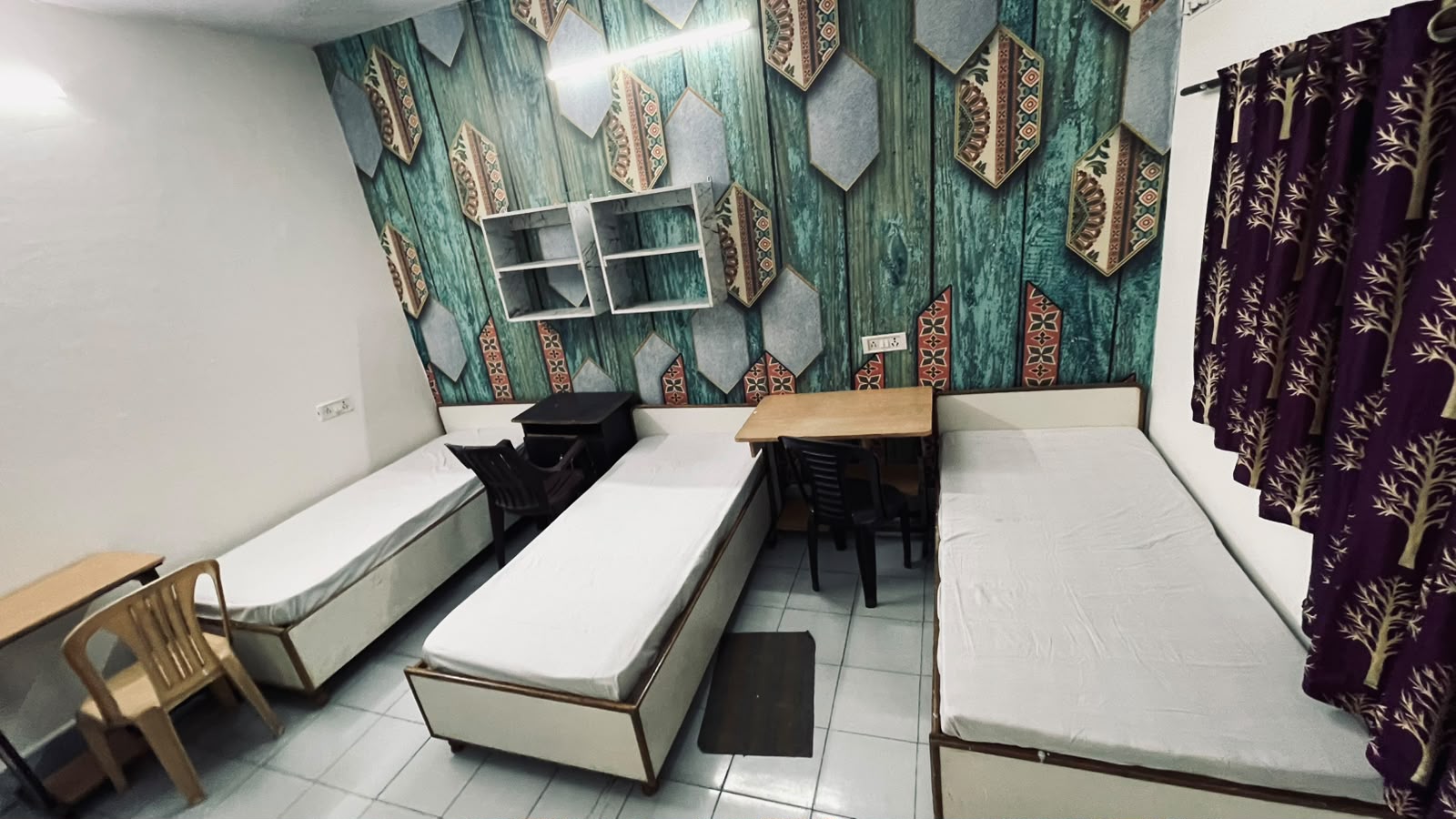 Triple sharing room with study tables and chairs