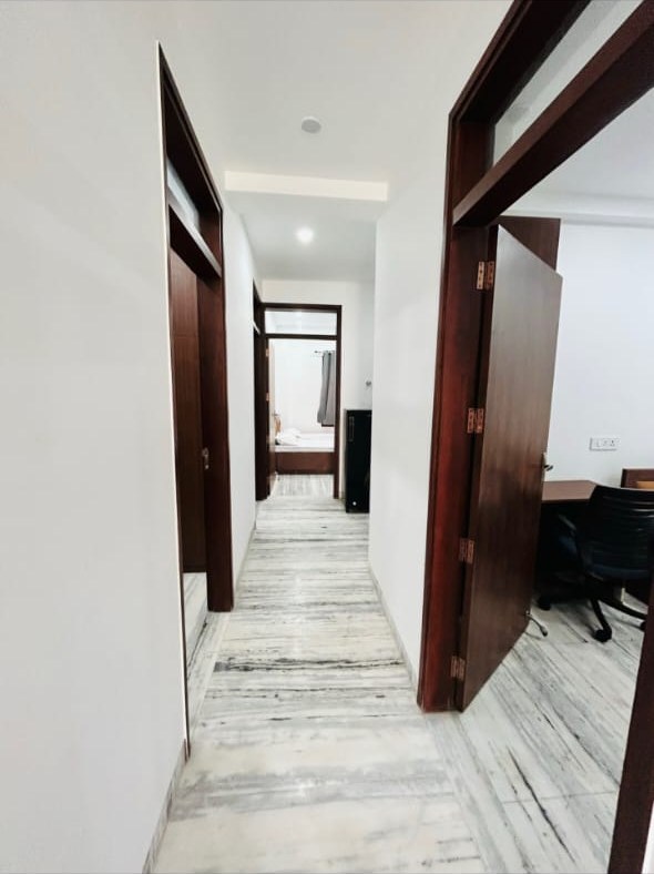 Wide marble-finish corridor between rooms